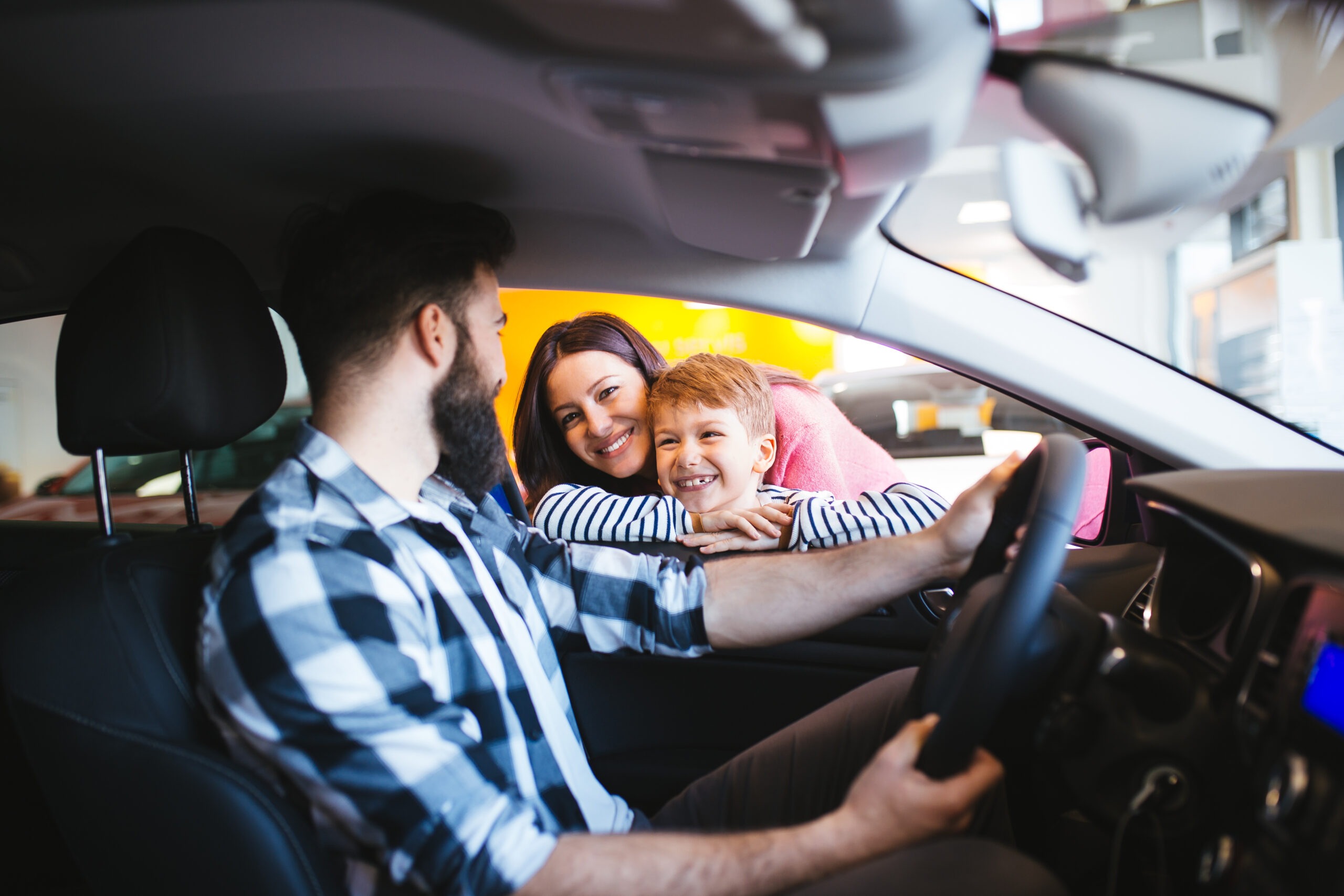 Happy family buying a new car at the car showroom.